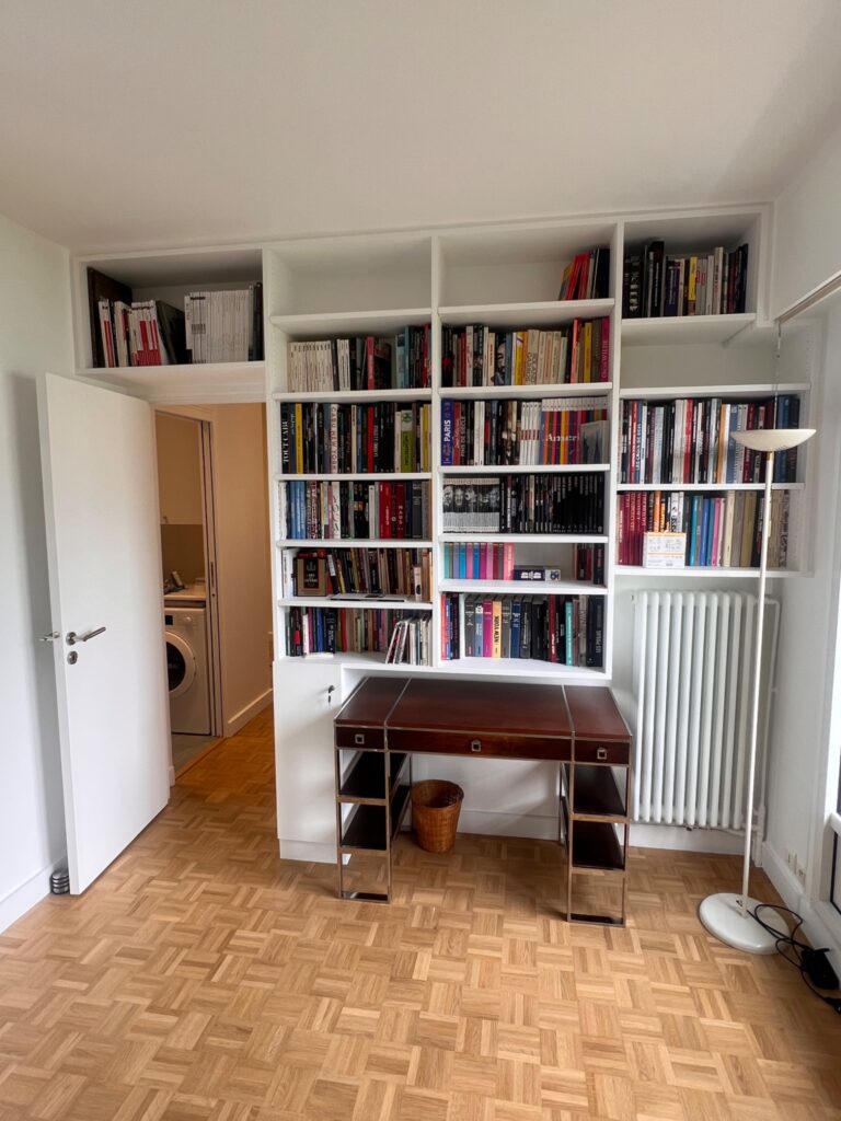 Bibliothèque murale sur mesure remplie de livres avec espace bureau intégré à Saint-Mandé