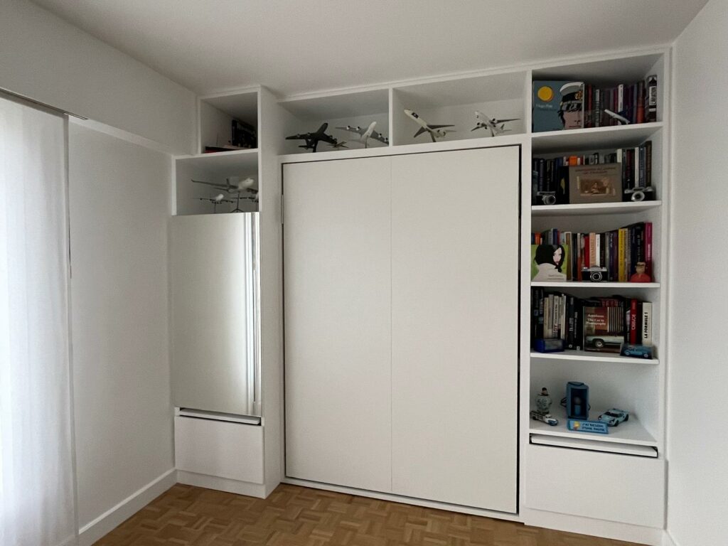 Lit escamotable fermé dissimulé dans une bibliothèque murale sur mesure à Saint-Mandé