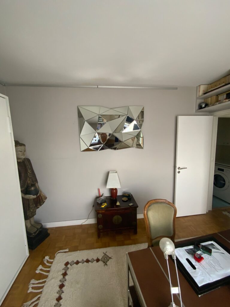 Mur du bureau existant avec miroir décoratif et mobilier avant rénovation à Saint-Mandé