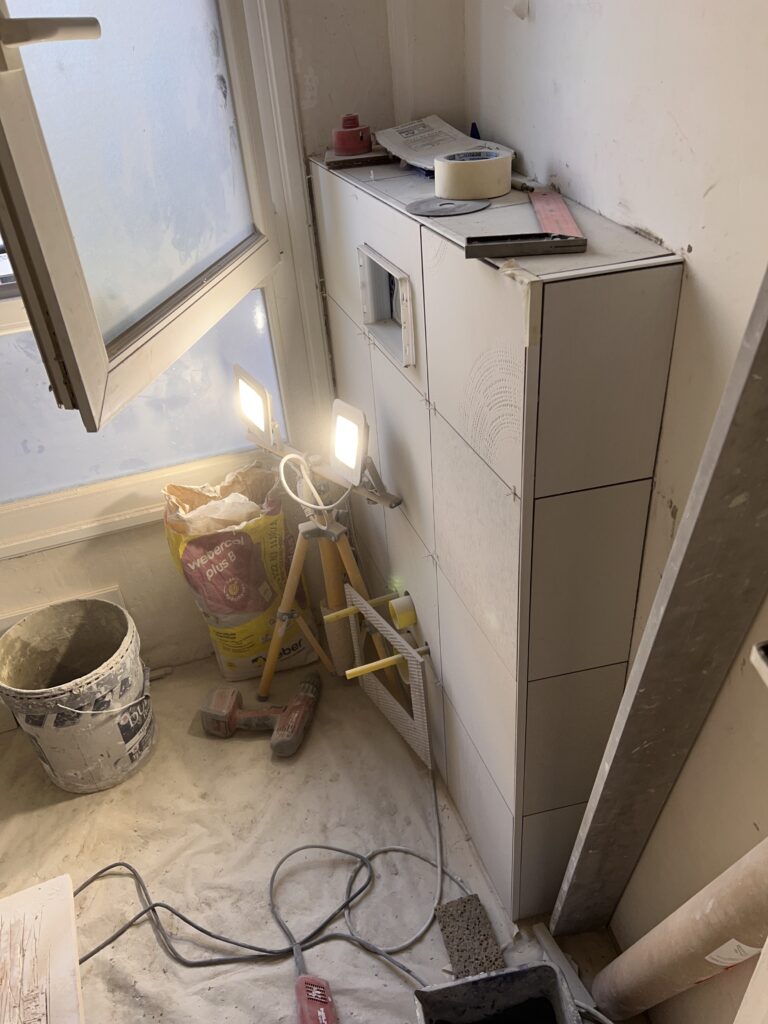 Vue du chantier en cours avec pose du carrelage et équipement sanitaires à Saint-Mandé.