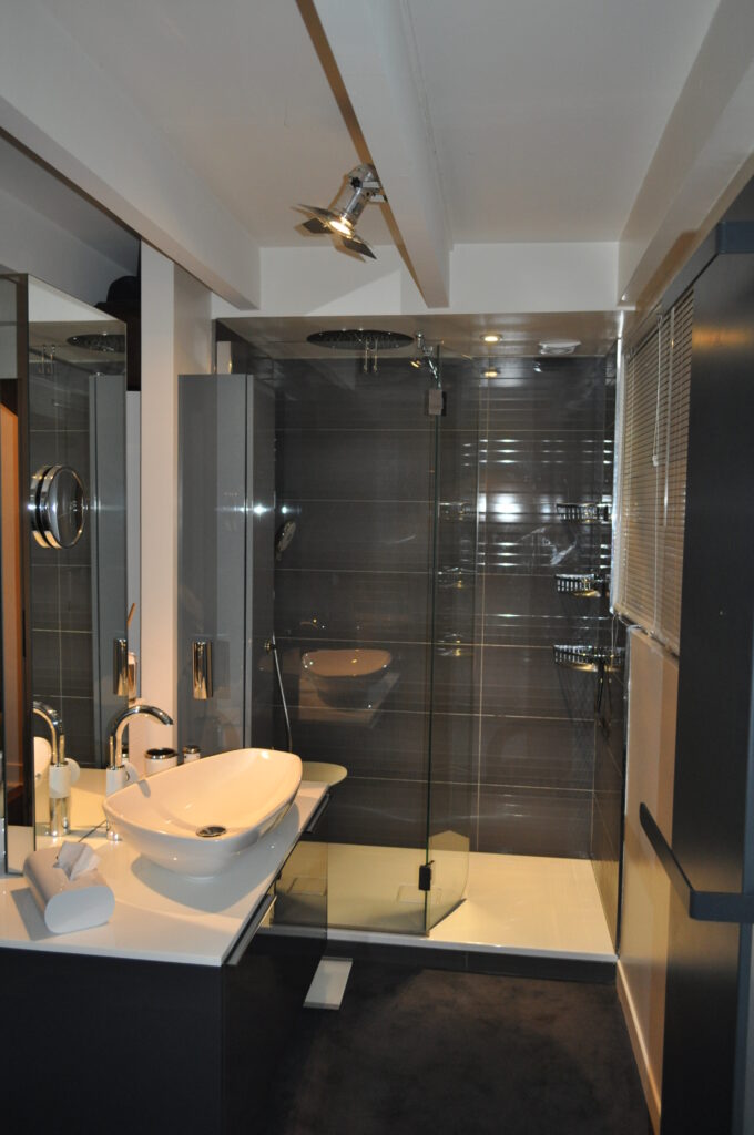 Salle de bains parentale à Vincennes – douche à l’italienne et vasque design Salle de bains parentale à Vincennes avec douche à l’italienne, meuble vasque îlot central design et carrelage gris brillant