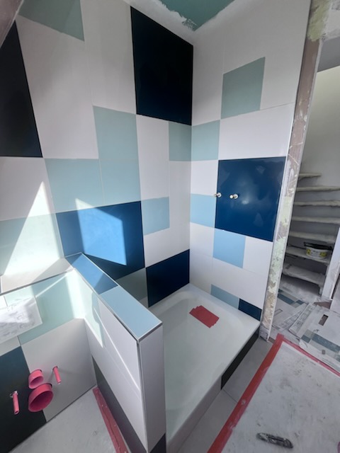 Carrelage mural presque terminé dans la douche sous combles