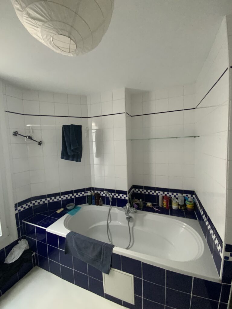 Salle de bains avant rénovation à Paris 9 avec baignoire encastrée et carrelage bleu