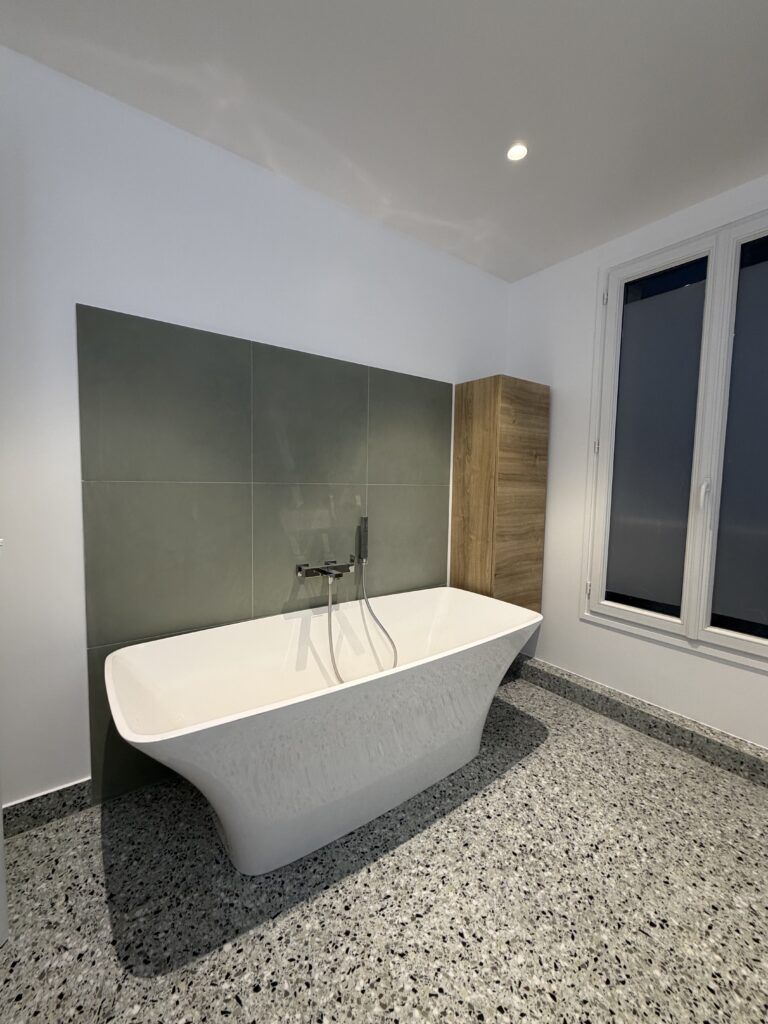 Baignoire îlot moderne avec mitigeur mural chromé et carrelage vert sauge