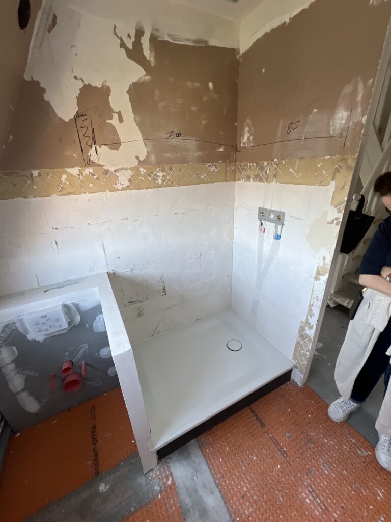 Receveur de douche en cours d’installation dans une salle de bains sous combles