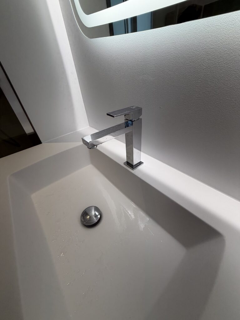 Robinetterie chromée contemporaine sur plan vasque blanc