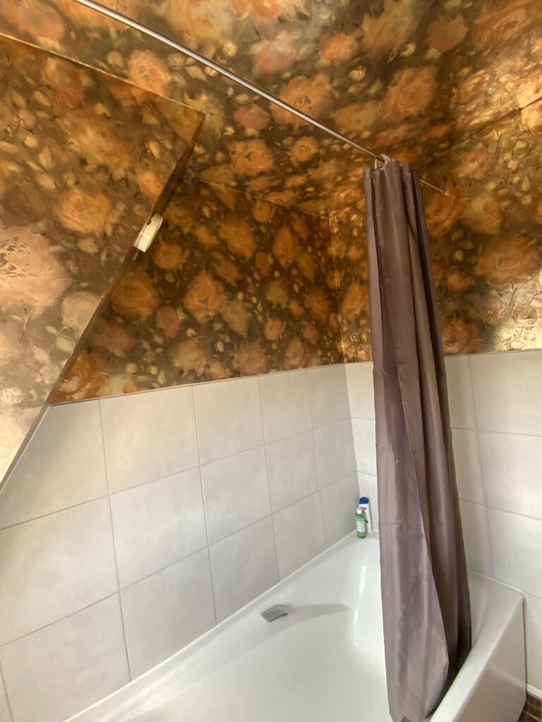 Baignoire installée sous pente dans une salle de bains avant rénovation à Deauville