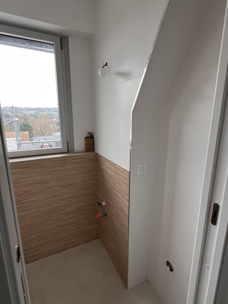 Création d’une cloison pour intégrer une porte coulissante dans une petite salle de bains à Deauville