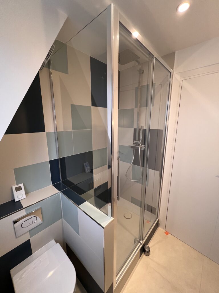Espace douche vitré et WC intégré dans une salle de douche sous combles rénovée